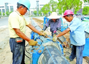 7月21日工人们正在宜城人民南路忙着铺设人行道