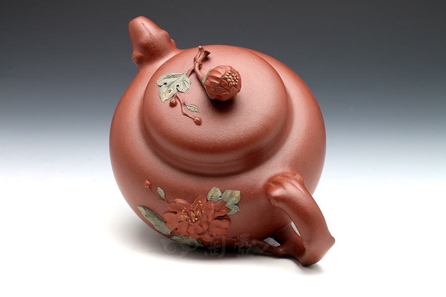 壶身继承传统的圆器形态,轮廓饱满,线条圆润,一朵红艳的牡丹花做壶钮